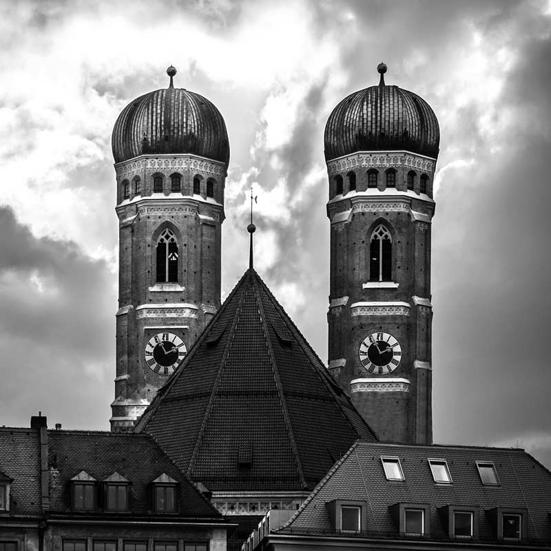 Schwarzweiss-Foto der Frauenkirche in München, die beiden Türme im Mittelpunkt